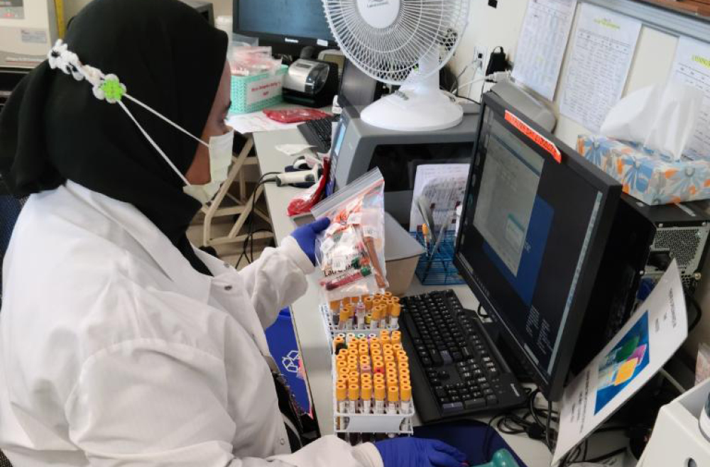A technician in Central Receiving examines incoming lab samples and verifies the labels.
